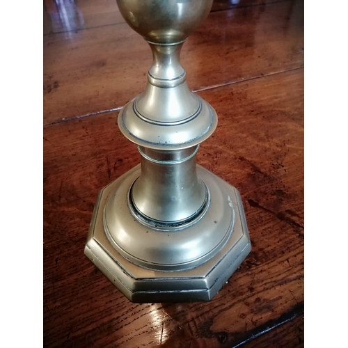 107 - A pair of tall antique brass candlesticks, having drip pans above slender stems to octagonal bases, ... 