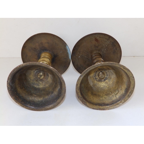 123 - A near pair of late 17thC turned brass candlesticks in Heemskirk style, the stems of ring turned for... 