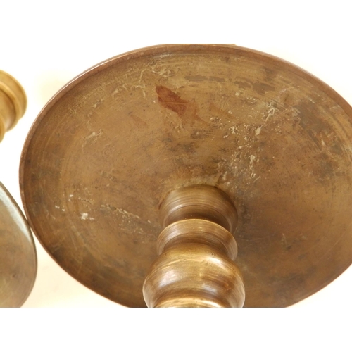 123 - A near pair of late 17thC turned brass candlesticks in Heemskirk style, the stems of ring turned for... 