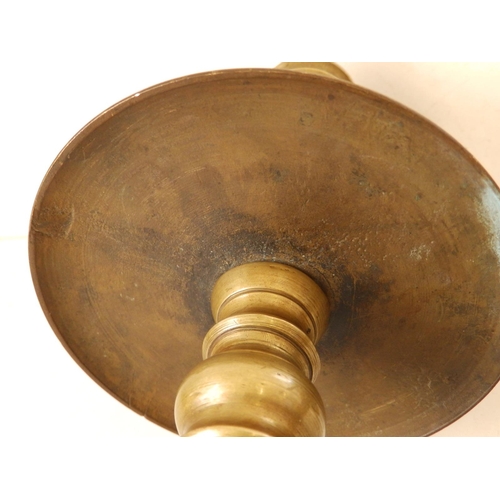 123 - A near pair of late 17thC turned brass candlesticks in Heemskirk style, the stems of ring turned for... 