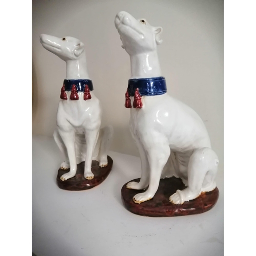 67 - A pair of seated white glazed dogs with blue collars, 14