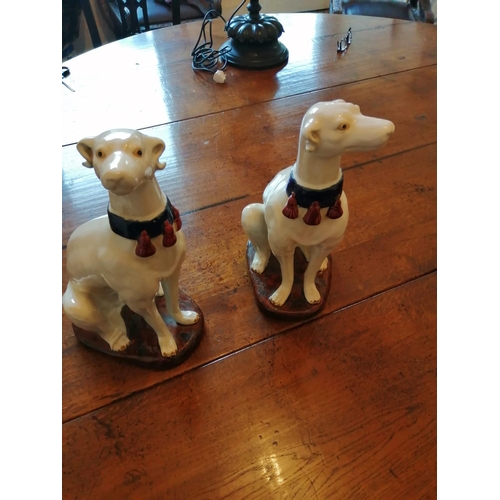 67 - A pair of seated white glazed dogs with blue collars, 14