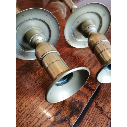 107 - A pair of tall antique brass candlesticks, having drip pans above slender stems to octagonal bases, ... 