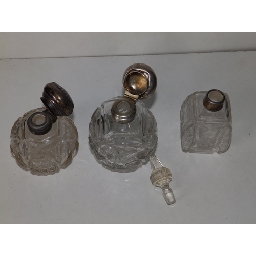 135 - Three silver mounted cut glass scent bottles, the tallest 6.4