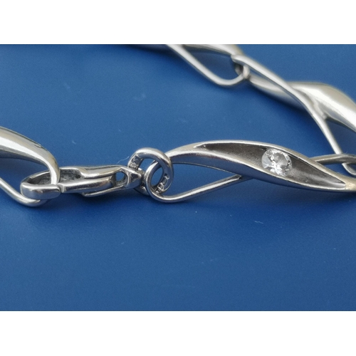 211 - A platinum bracelet of modern design comprising seven elongated twisted links each set with a brilli... 