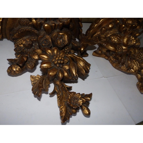 125c - A pair of Victorian carved giltwood wall brackets, each decorated profusely with flowerheads and a b... 