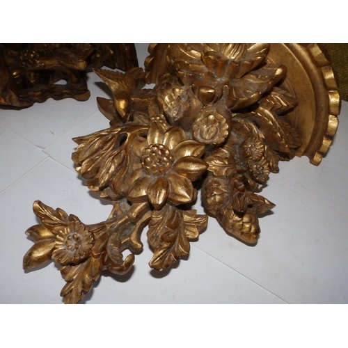 125c - A pair of Victorian carved giltwood wall brackets, each decorated profusely with flowerheads and a b... 