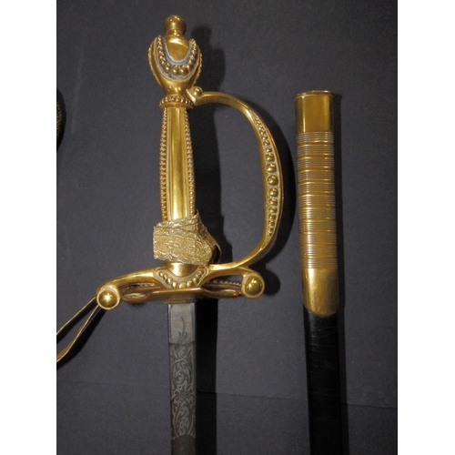 128 - An Edwardian court sword with gilt hilt and decorated blade in (repaired) leather scabbard, the blad... 