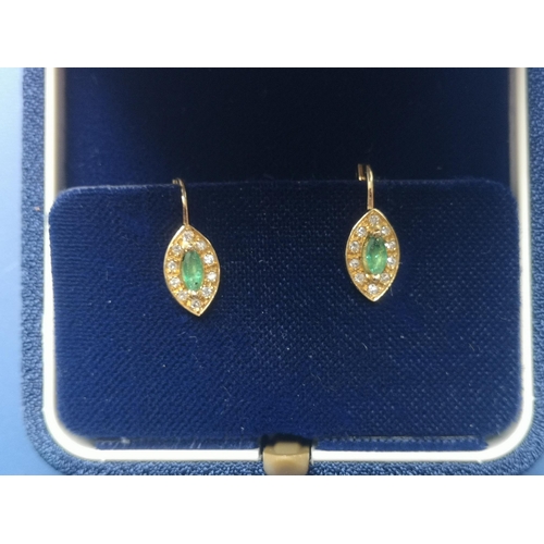 173 - A pair of emerald & diamond marquise cluster earrings in 750 yellow metal, the setings 10mm across. ... 