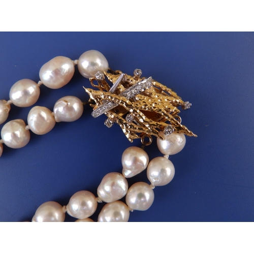 192 - A twin strand baroque pearl necklace, average girth of pearls between 8 & 9mm, the diamond set 18c c... 