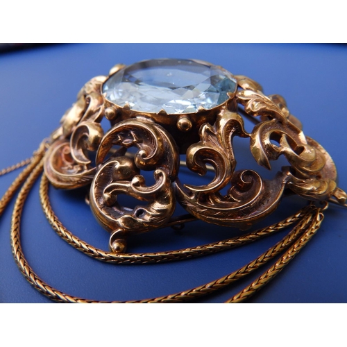 201 - A large Victorian aquamarine set brooch, of oval open scroll form, set with a large faceted oval aqu... 