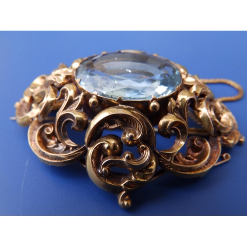 201 - A large Victorian aquamarine set brooch, of oval open scroll form, set with a large faceted oval aqu... 