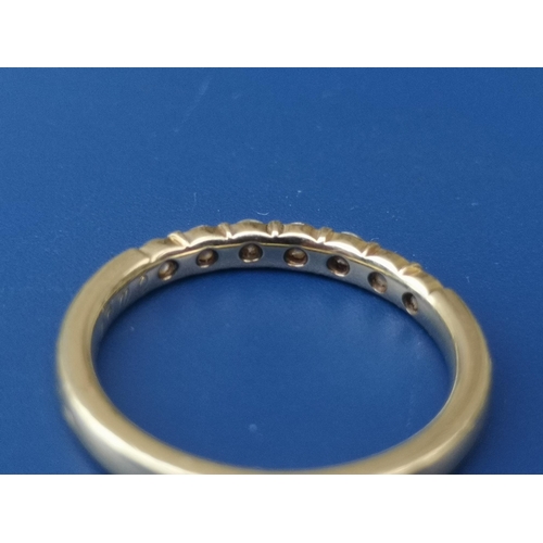 203 - A small modern seven stone diamond half eternity style ring on 585 metal shank.  Finger size L.