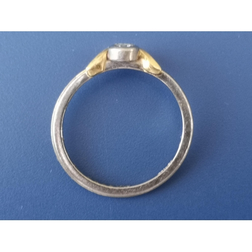 212 - A small diamond collet set 18ct gold solitaire ring in wishbone setting.  Finger size K.