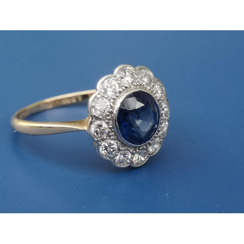 214 - A circular sapphire & diamond cluster ring, the sapphire measuring approximately 6mm diameter - '18c... 