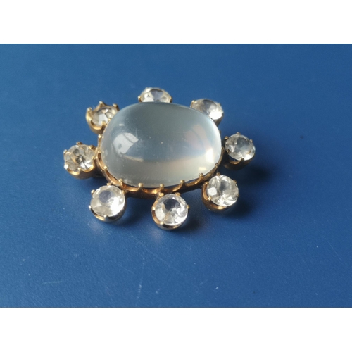 217 - An oval moonstone cluster brooch, surrounded by seven colourless stones and one replacement paste, i... 