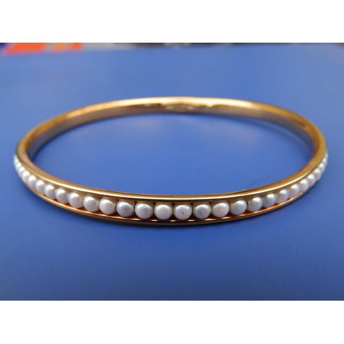 227 - A pearl set 750 metal bangle, diameter 3