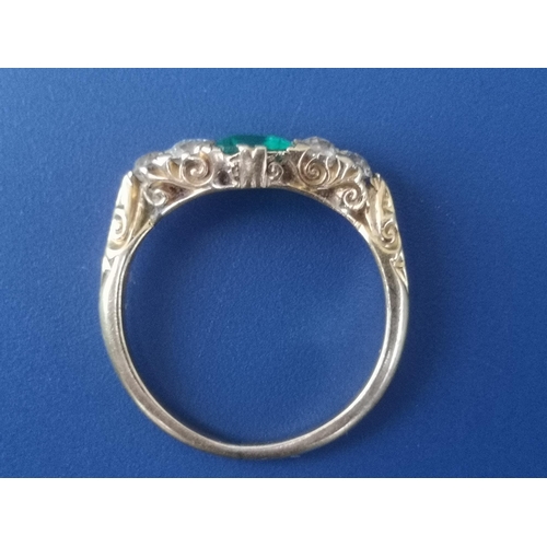 231 - An emerald & diamond ring, the rectangular cut emerald flanked by six small old cut diamonds on yell... 