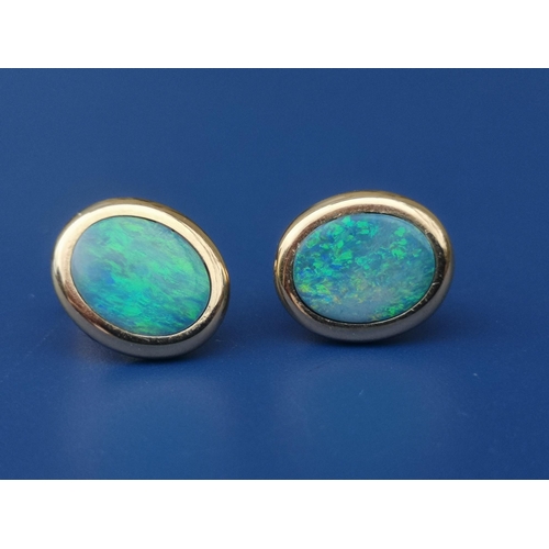 249 - A pair of oval opal panel earrings - 14K, 11mm overall.