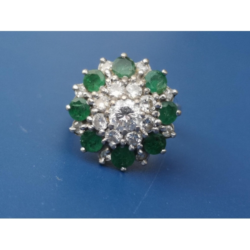 262 - An emerald & diamond set 18ct white gold target cluster ring.  Finger size N.