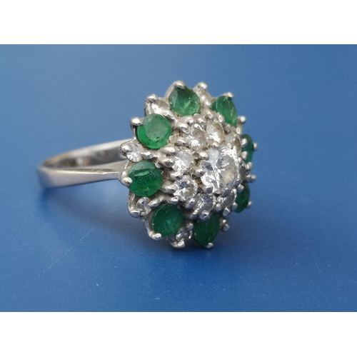 262 - An emerald & diamond set 18ct white gold target cluster ring.  Finger size N.