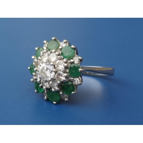 262 - An emerald & diamond set 18ct white gold target cluster ring.  Finger size N.