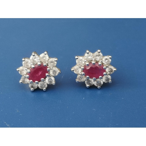 264 - A pair of modern ruby & diamond set 18ct gold oval cluster earrings, 11mm overall. (2)