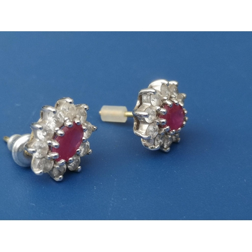 264 - A pair of modern ruby & diamond set 18ct gold oval cluster earrings, 11mm overall. (2)