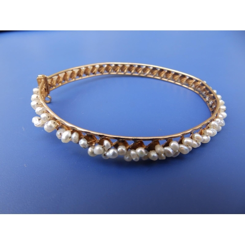 272 - A seed pearl set yellow metal openwork bangle, 2.5