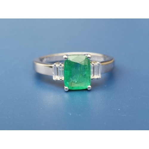 274 - A rectangular cut emerald & diamond ring , the central four-claw set emerald flanked by four small d... 