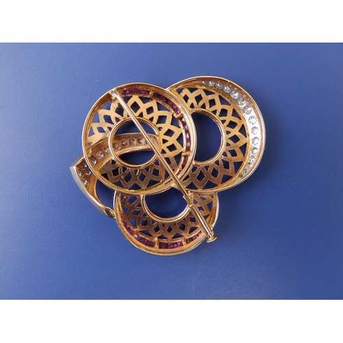 281 - A diamond & ruby set yellow metal sunflower brooch, formed as three conjoined stylised openwork flow... 