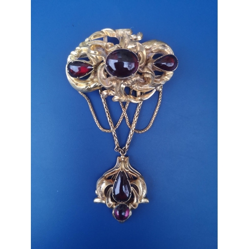 287 - A Victorian cabochon set brooch with festooned drop, of asymmetrical foliate open scroll form, set w... 