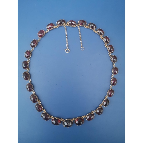 288 - A 19thC graduated garnet set riviere necklace, the faceted oval stones held in crown-shaped claws, 1... 