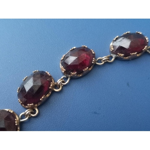 288 - A 19thC graduated garnet set riviere necklace, the faceted oval stones held in crown-shaped claws, 1... 