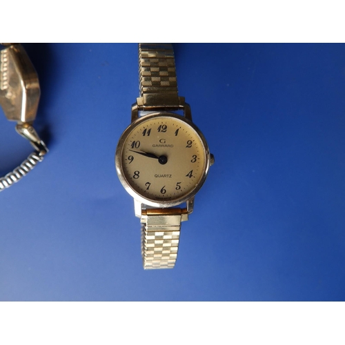 292 - A boxed lady's Garrard gold presentation wrist watch on plated strap, two other ladies' gold watches... 