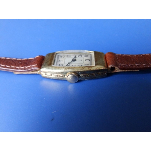 302 - An art deco lady's gold Omega wrist watch in tonneau shaped case on replacement leather strap.