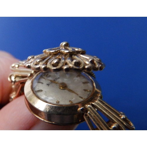 323 - A lady's 9ct gold 'Helvetia' bracelet wrist watch with concealed dial.