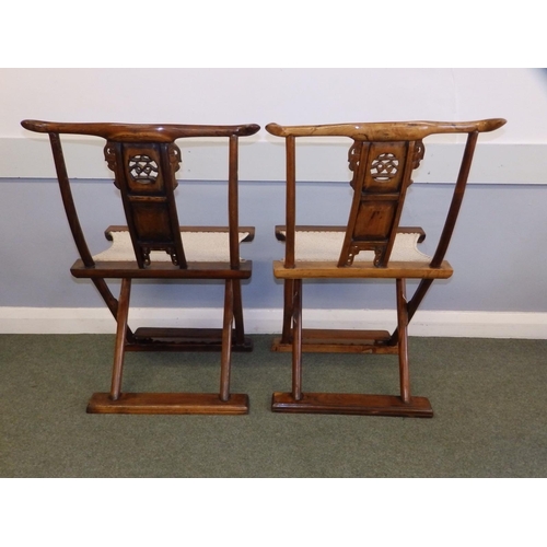 47 - A pair of Chinese folding chairs, having carved splats and footrests, Height 38