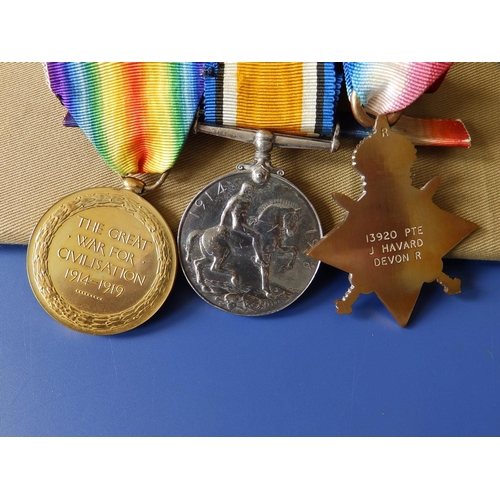 58 - A WWI medal trio including the 1914-15 Star with ribbon bar awarded to 13920 Pte. J. Havard, Devon R... 