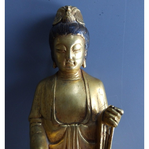 52 - A Chinese gilt bronze figure of  a standing Buddha with rooster headdress, on dark patinated octagon... 