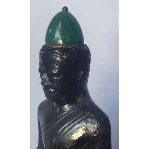 59 - An Asian silver covered Buddha with applied jade panel and hat, 5.2