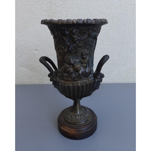 109 - A bronze campana shaped urn decorated bacchanalian putti, 9