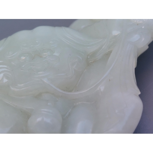 137 - A Chinese jade group depicting an Immortal at play with a Shishi, 3.5