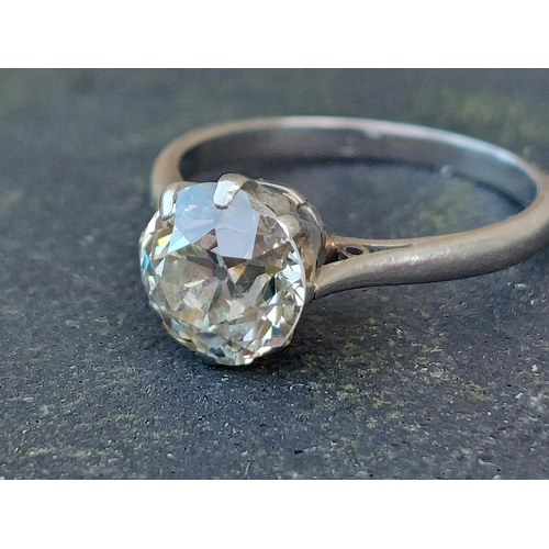 303 - An old cut diamond solitaire ring, the claw set stone weighing approximately 1.7 carats on white met... 