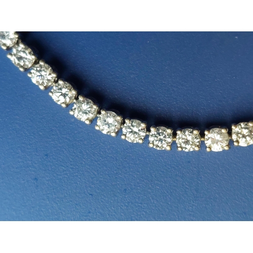 307 - A diamond set line bracelet, comprising 61 claw set stones - testing as 18ct white gold, 7.9