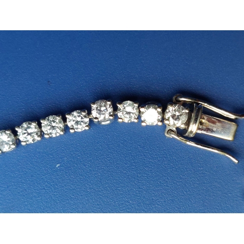 307 - A diamond set line bracelet, comprising 61 claw set stones - testing as 18ct white gold, 7.9