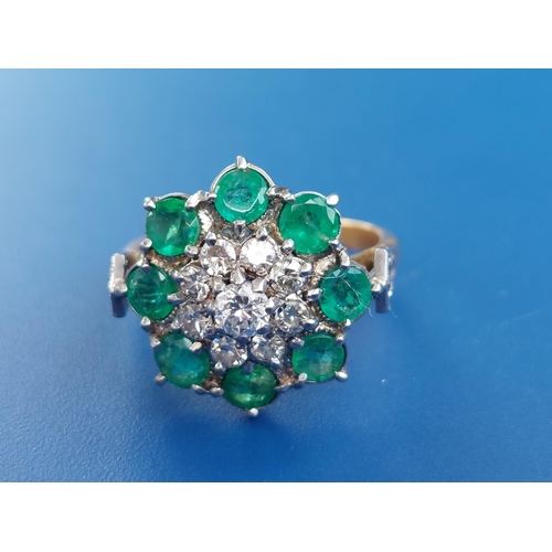 238 - An emerald & diamond set cluster ring on yellow metal shank.  Finger size N.