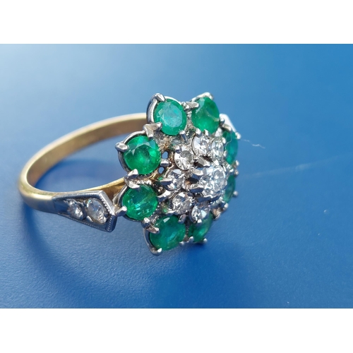 238 - An emerald & diamond set cluster ring on yellow metal shank.  Finger size N.