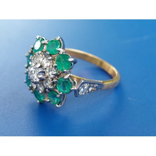 238 - An emerald & diamond set cluster ring on yellow metal shank.  Finger size N.