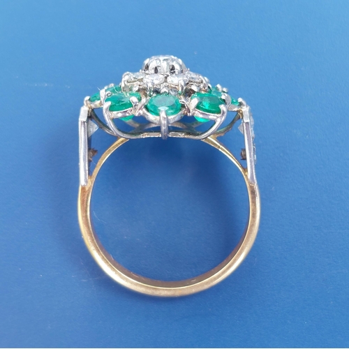 238 - An emerald & diamond set cluster ring on yellow metal shank.  Finger size N.